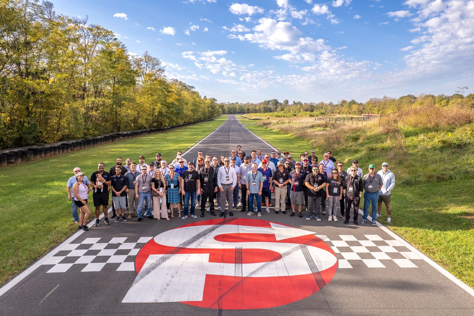 Group photo of Government Technology Leadership Forum attendees on the start-finish line at Summit Point