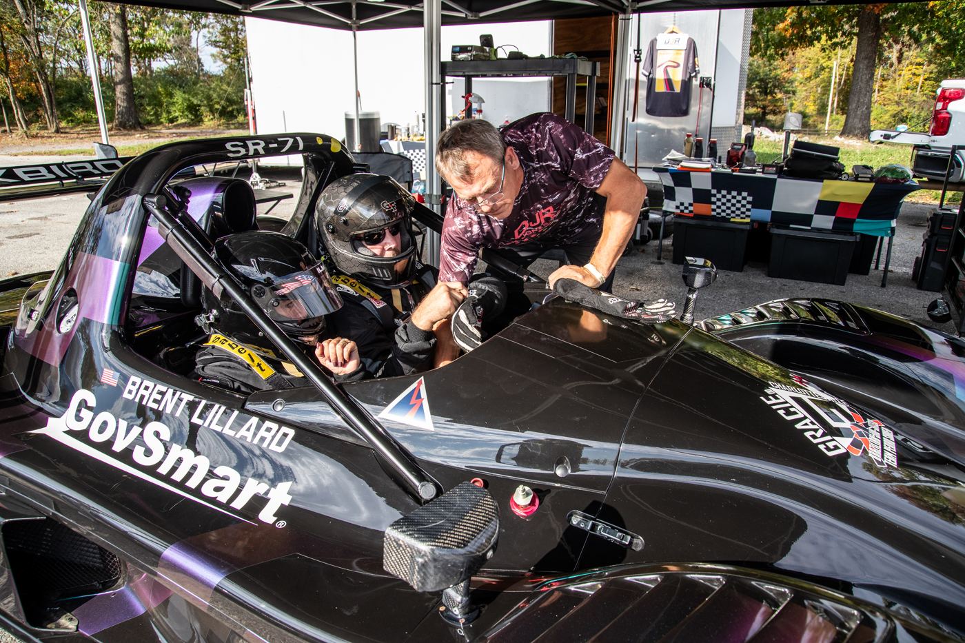 A driver getting strapped into the Radical with Brent Lillard's name on the side